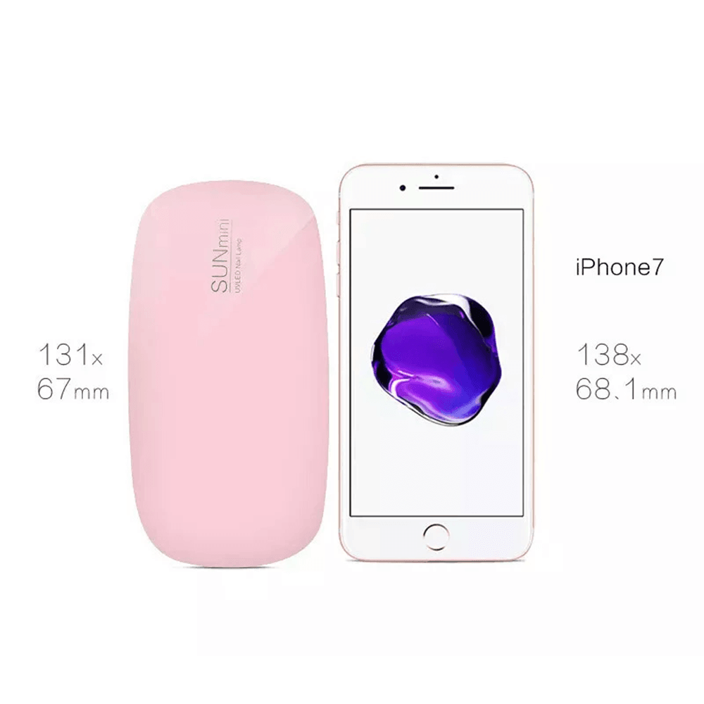 Pink mini UV LED nail lamp shown next to a smartphone to demonstrate its compact, portable size for travel manicures.