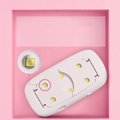 Close-up of white mini UV LED nail lamp beads and portable folding legs for gel polish manicures.