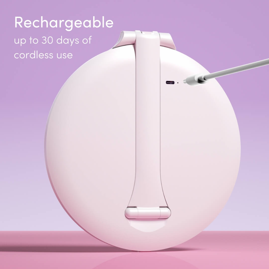 Abigail LED travel makeup mirror in white being charged via USB cable on a lavender background.