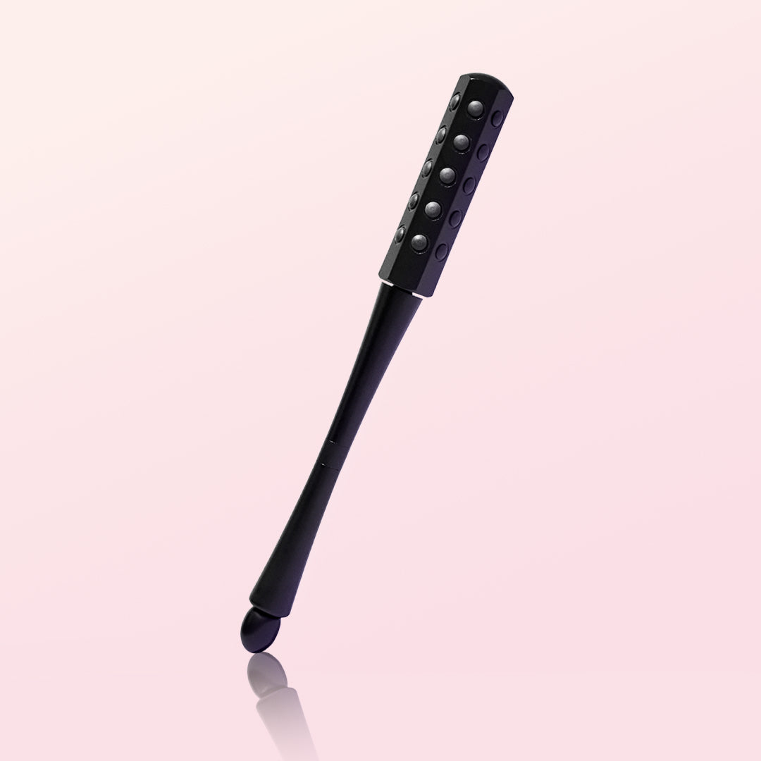 Remi Uplift black facial massage roller with germanium-infused stones and a gua sha handle end for skin firming.