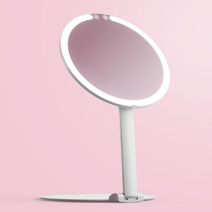 White Abigail LED travel makeup mirror with ring light and adjustable stand on a pink background.