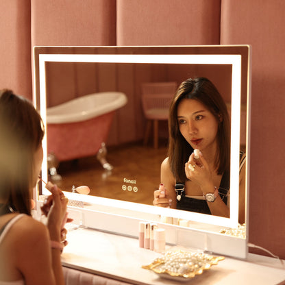 Woman using Monroe Hollywood Vanity Mirror with Omni-Glow LED lighting for professional makeup application.