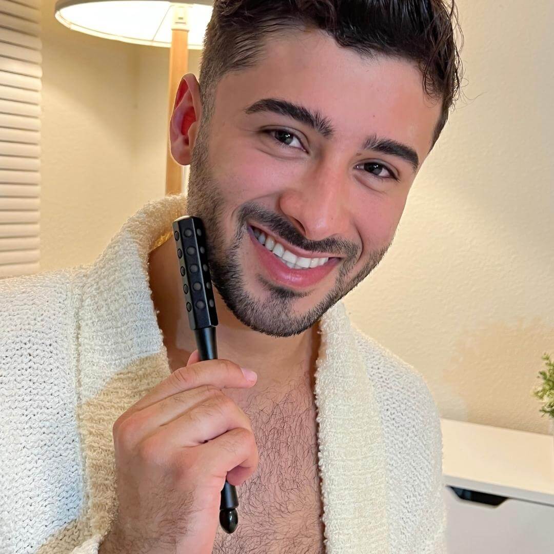 Man using Remi germanium-infused facial roller on his neck for skin tightening and a relaxing massage.