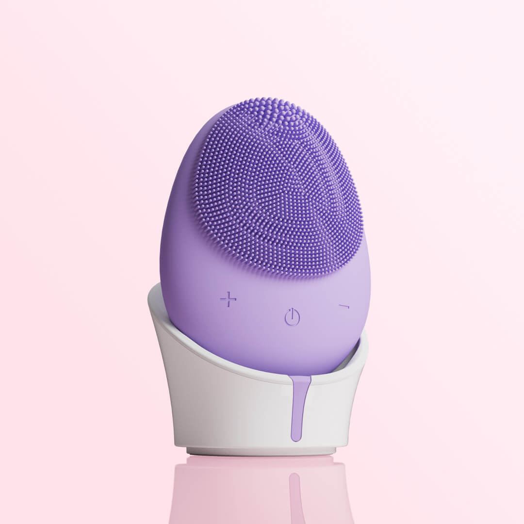 Isla purple silicone sonic facial cleansing brush with exfoliating bristles on a white charging stand.