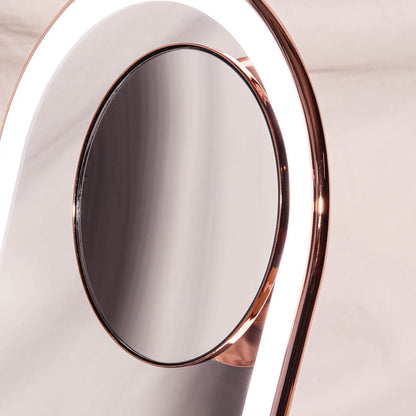 Lara 10x magnifying makeup mirror magnetically attached to the lighted Vera vanity mirror with a rose gold finish.