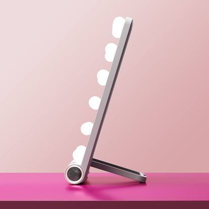 Side view of the Madeline Mini Hollywood Mirror with LED bulbs, Bluetooth speaker, and kickstand on a pink surface.