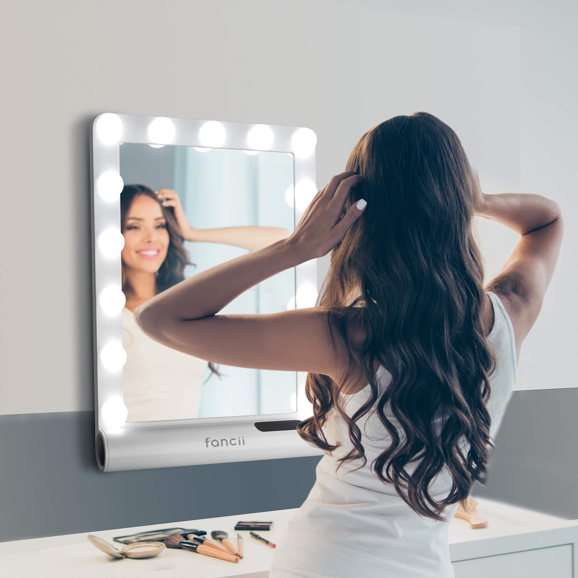 Madeline Mini Hollywood Mirror with LED bulbs and Bluetooth speaker, used for makeup and hair styling at a vanity desk.