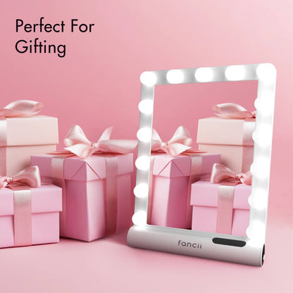 Madeline Mini Hollywood Mirror with LED lights and Bluetooth speaker, shown with pink gift boxes for gifting.