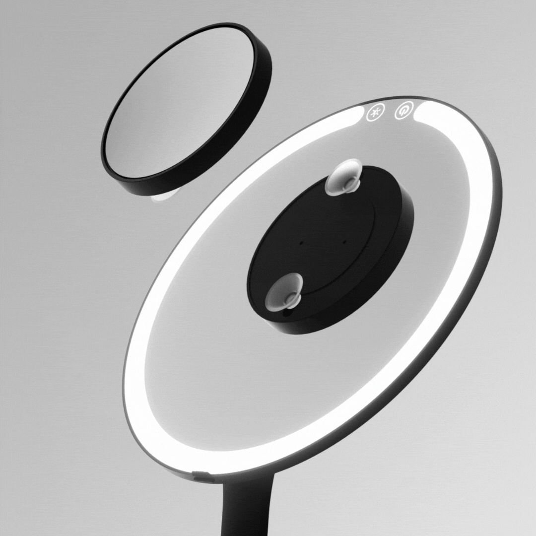 Tara 10x Magnifying Suction Mirror with black frame shown attaching to a larger illuminated LED vanity mirror.
