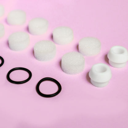 Clara Essential Kit replacement parts: white foam filters, black rubber rings, and silicone tips for pore cleanser.