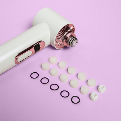 Clara Essential Kit replacement filters, rubber rings, and silicone tips for 4-in-1 Pore Cleanser on pink background.