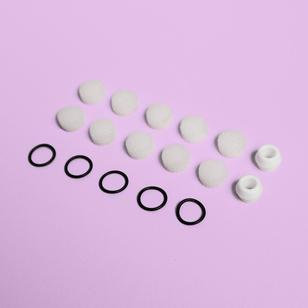 Clara Essential Kit replacement parts: 10 white foam suction filters, 5 black rubber rings, and 2 silicone tips.