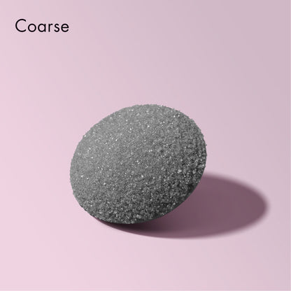 Close-up of a Cali Coarse replacement head for a foot callus remover, featuring a textured grey surface on a pink background.