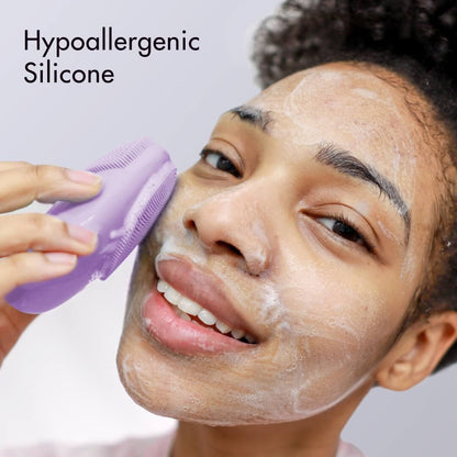 Isla purple hypoallergenic silicone sonic facial cleansing brush used by a smiling woman to exfoliate skin.