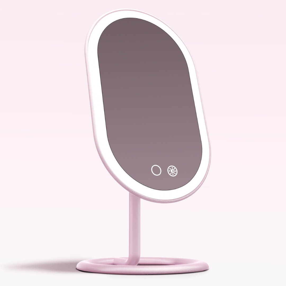 Vera pink lighted vanity mirror with LED ring light, rechargeable touch controls, and adjustable tilt on a sturdy base.