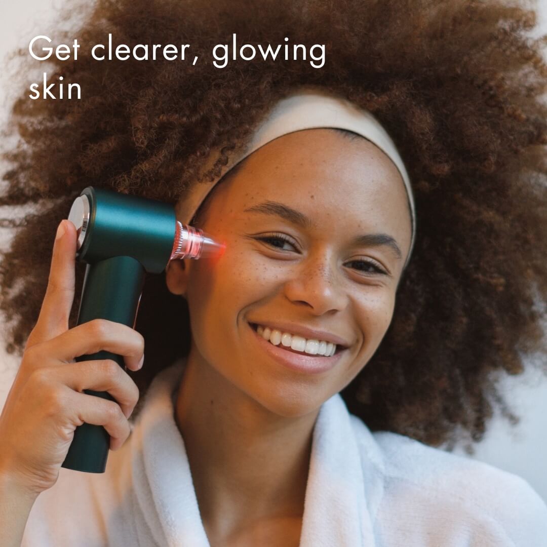 Woman using Clara Microdermabrasion Device and blackhead remover with red LED light therapy for glowing skin.
